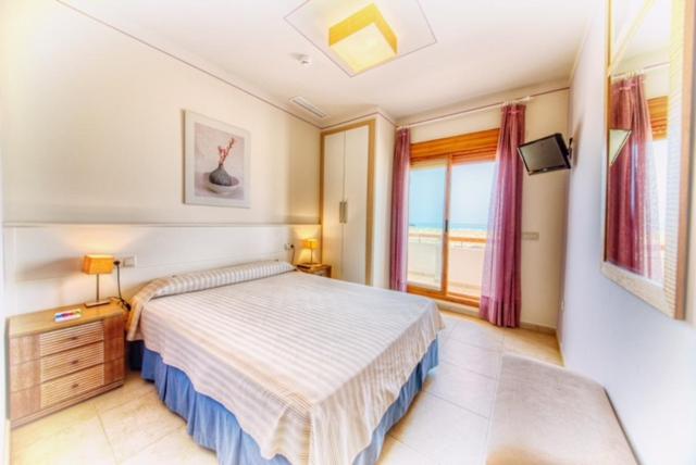 a bedroom with a large bed and a window at Colores de Zahara in Zahara de los Atunes