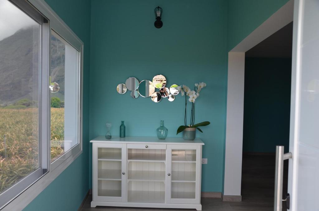 Casa Elvira Frontera في فرونتيرا: غرفة زرقاء مع خزانة بيضاء ونافذة
