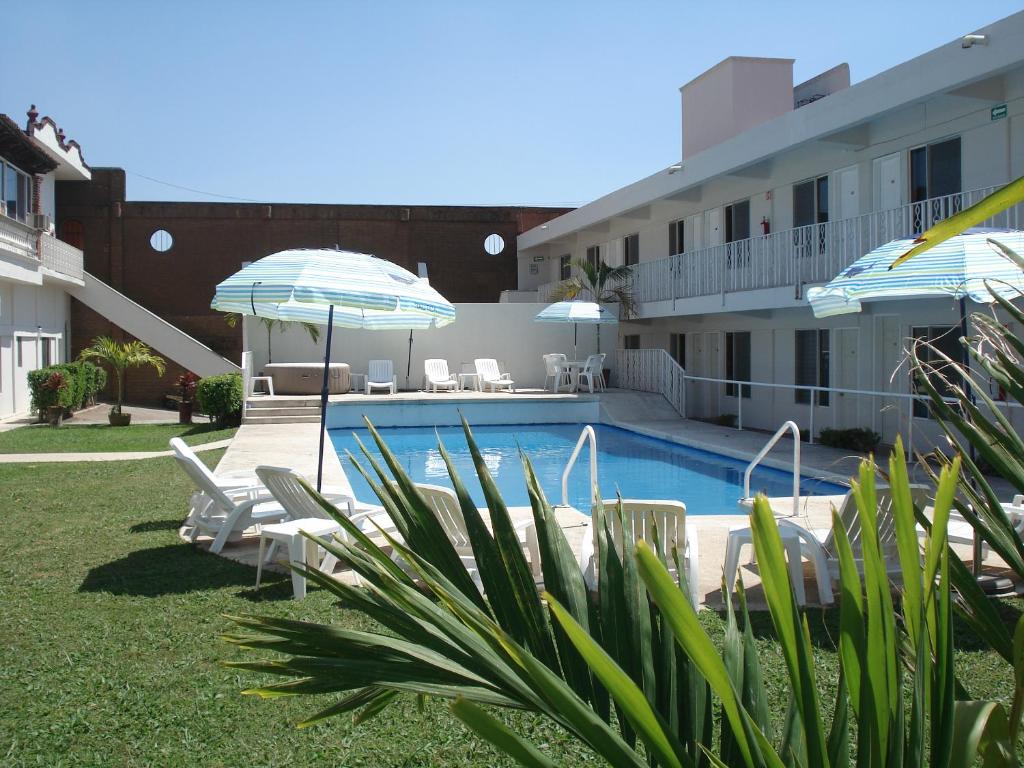 a swimming pool with chairs and umbrellas next to a building at AOHOM SANTUARIO HOTEL & SPA in Jiutepec