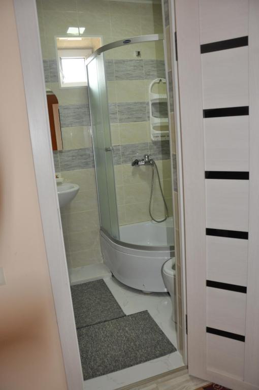 a bathroom with a shower and a toilet at Guest House Nur in Kochkor