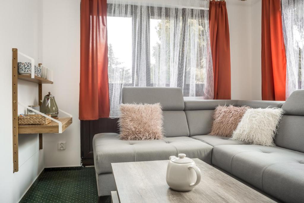 a living room with a couch and a table at Hotel Konopiště Nová Myslivna in Benešov