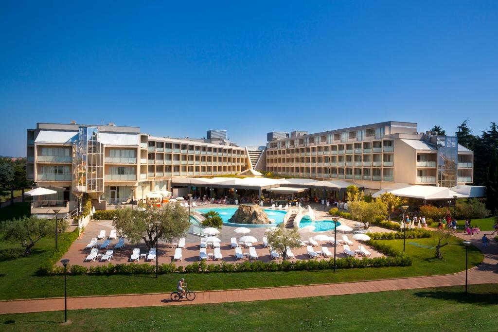 a resort with a swimming pool and a hotel at Aminess Vival Maestral Hotel in Novigrad Istria