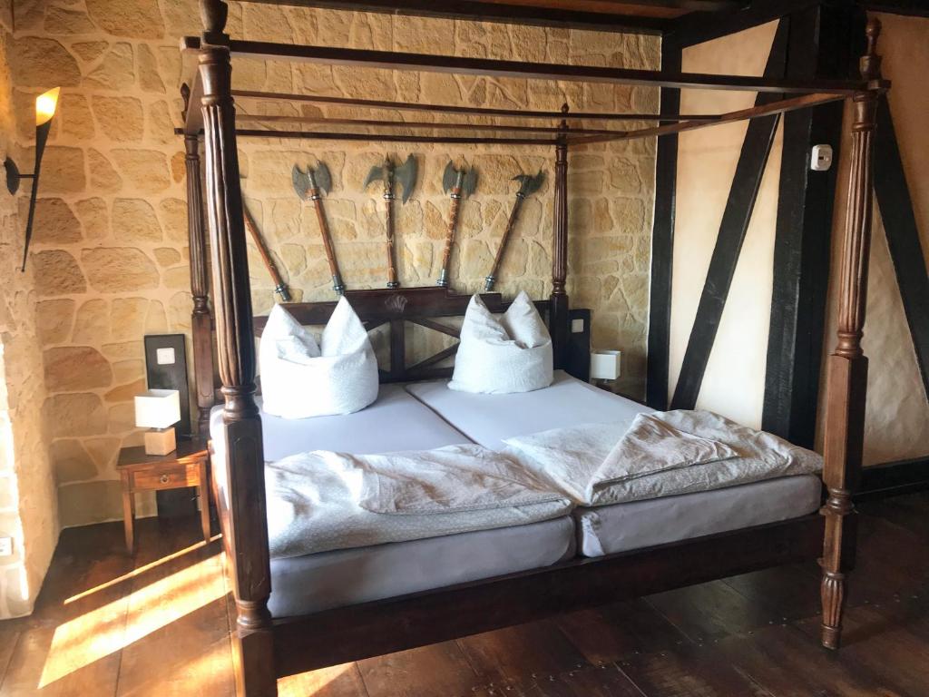 ein Himmelbett mit weißer Bettwäsche und Kissen darauf in der Unterkunft Ferienwohnung WACHSTUBE mit 3 Schlafräumen im Rittergut Leppersdorf in Wachau