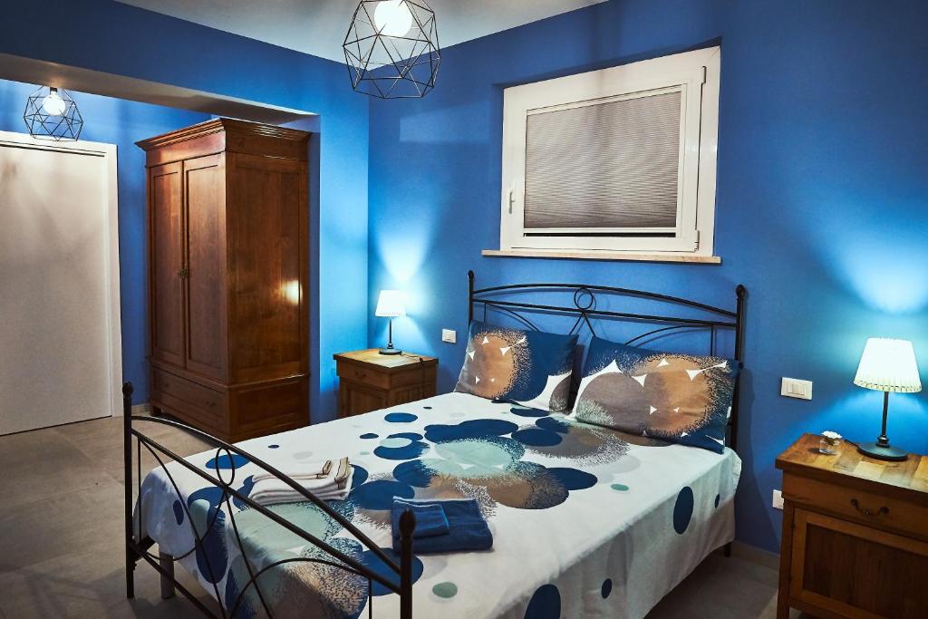 una camera con un letto con una parete blu di B&B Al Chicco d'Uva a Morro dʼAlba