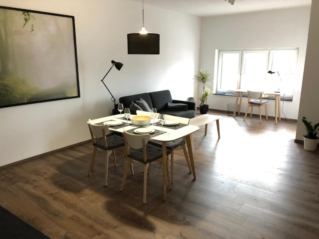 - un salon avec une table, des chaises et un canapé dans l'établissement Ferienwohnung Kirschholz, à Schmelz