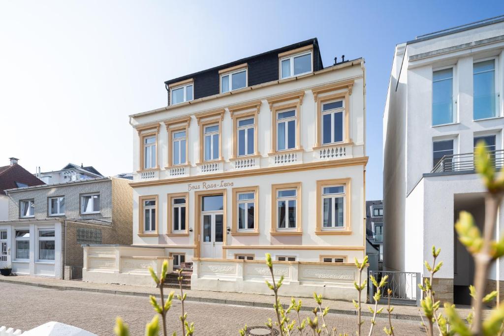 un gran edificio blanco en una calle de la ciudad en Logierhaus Rosa-Lena, en Norderney