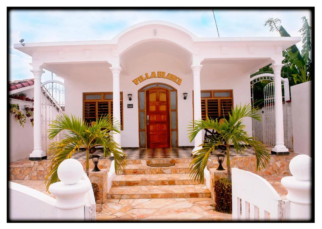 a white house with a red door at Hostal "Villa Blanca" in Caibarién