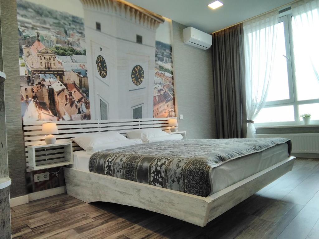 a bedroom with a large bed with a clock on the wall at Panorama Lviv in Lviv