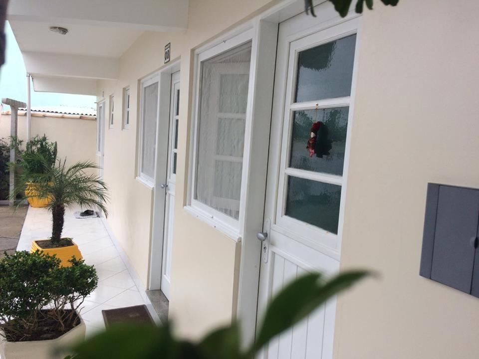una porta bianca di una casa con finestra di Pousada Rosa Norte a Tramandaí