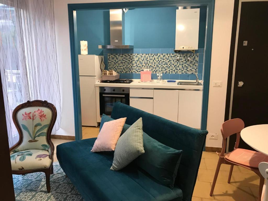sala de estar con sofá azul y cocina en Il Giglio, en Bordighera