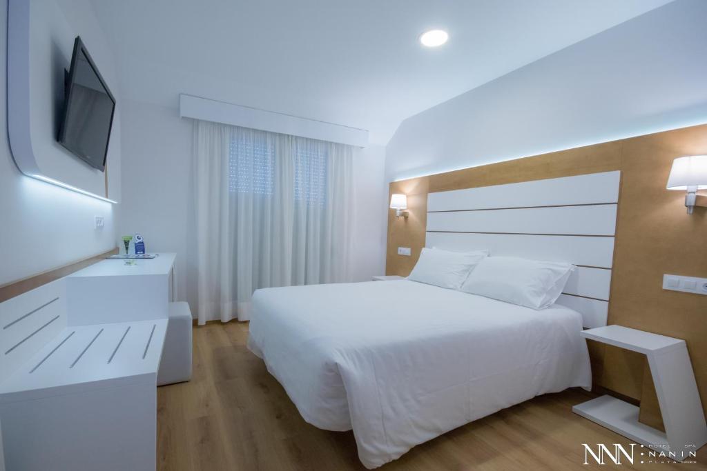 A bed or beds in a room at Hotel Spa Nanin Playa