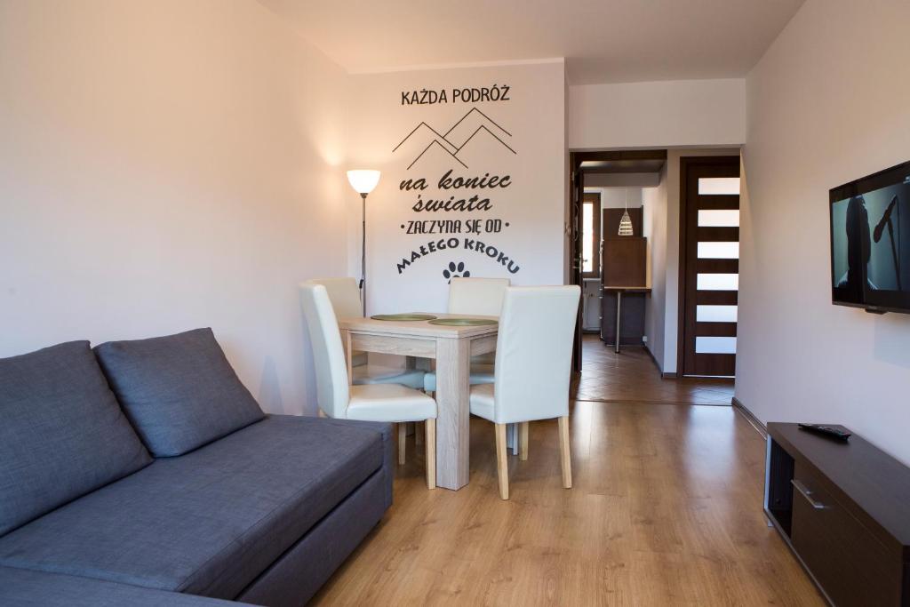 a living room with a couch and a table at May Land Apartment in Szklarska Poręba