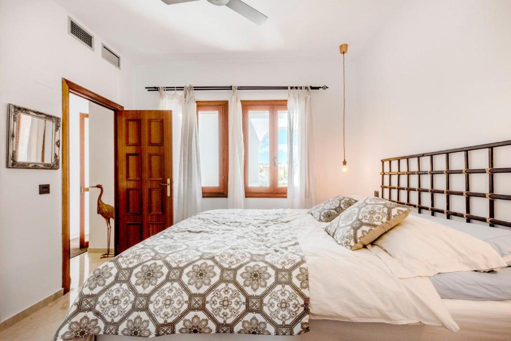 um quarto branco com uma cama grande e uma janela em Medina Penthouse em Marbella