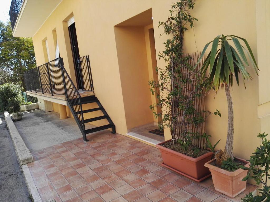 una casa con una escalera y macetas al lado en B&B ROSSELLA en Montegranaro