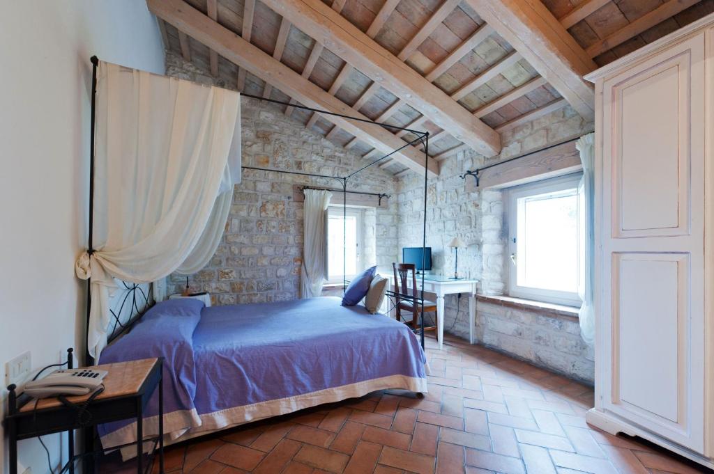 a bedroom with a bed and a table and a window at Valcastagno Relais in Sirolo