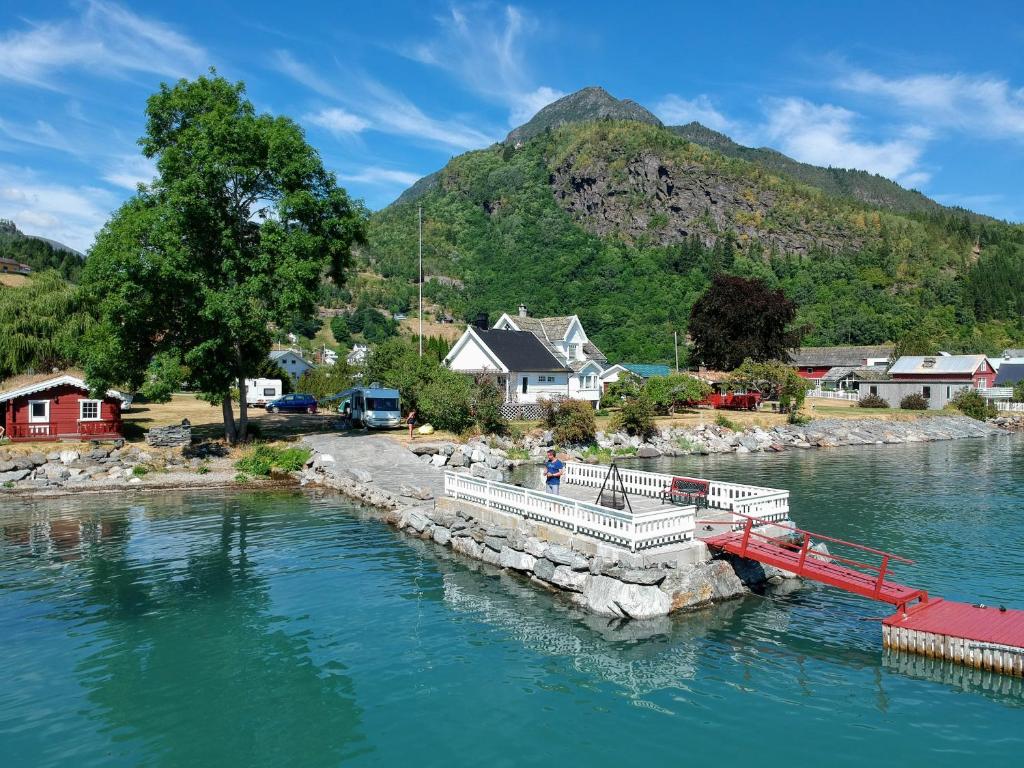 a boat is docked at a dock in a river at Dalsøren Camping og hytter in Luster