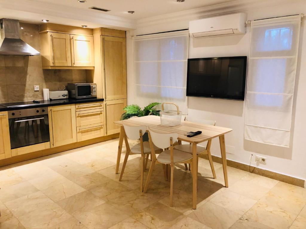 cocina con mesa y sillas y TV en PUERTO BANUS Apartamento LUCY, en Marbella