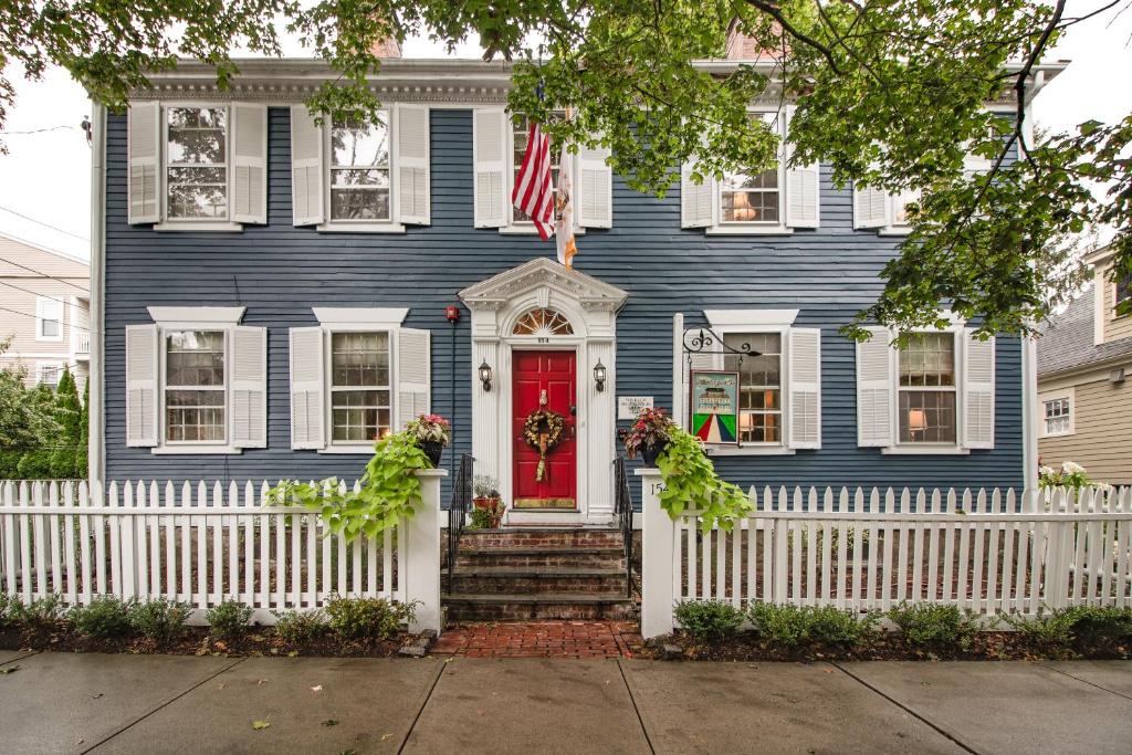 una casa azul con una valla blanca y una puerta roja en William's Grant Inn Bed and Breakfast, en Bristol