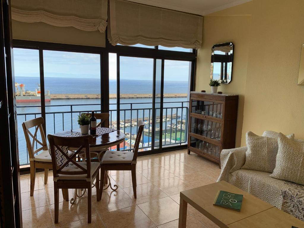 ein Wohnzimmer mit einem Tisch und Meerblick in der Unterkunft Dream Bahia in Santa Cruz de Tenerife