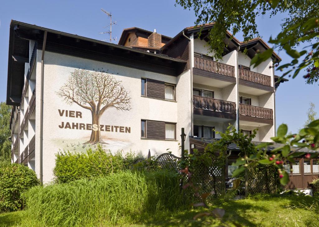un edificio con un árbol pintado a un lado. en Hotel Garni Vier Jahreszeiten en Bad Füssing