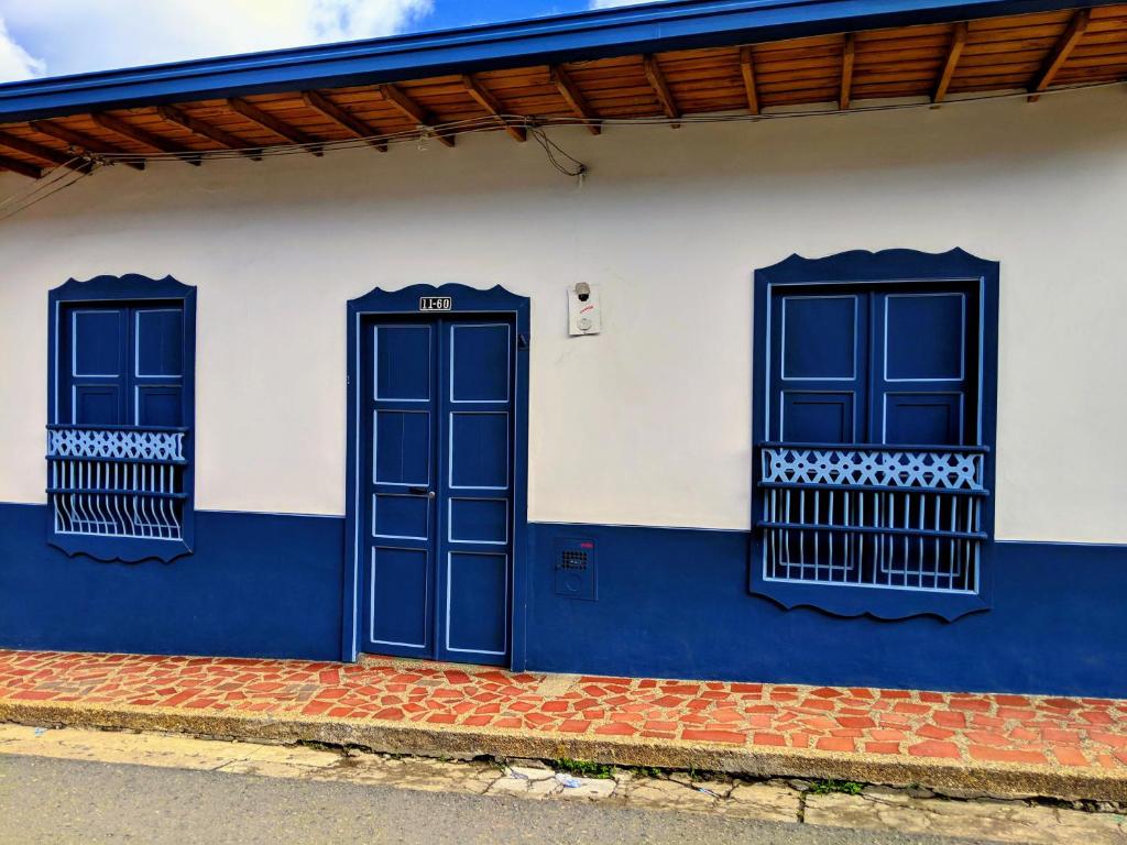 um edifício azul e branco com duas janelas em Vivienda Turística - Casa de Carola em Jardín