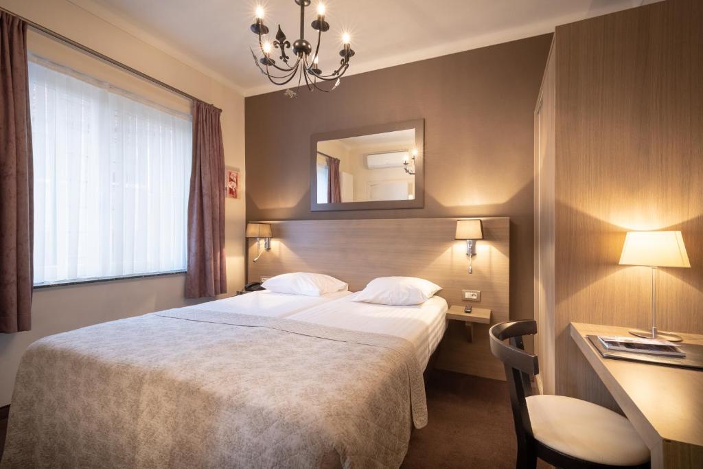 
a hotel room with a large bed and a large mirror at Hotel Albert I in Bruges
