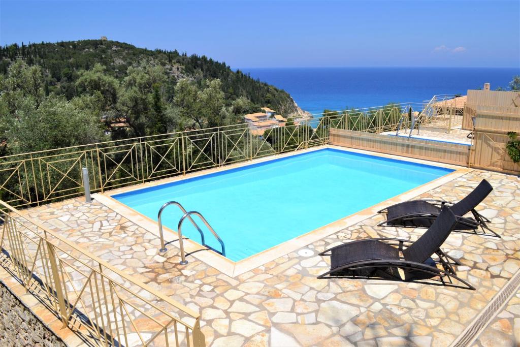 una piscina con 2 sillas y el océano en Agios Nikitas View 2 en Ayios Nikitas