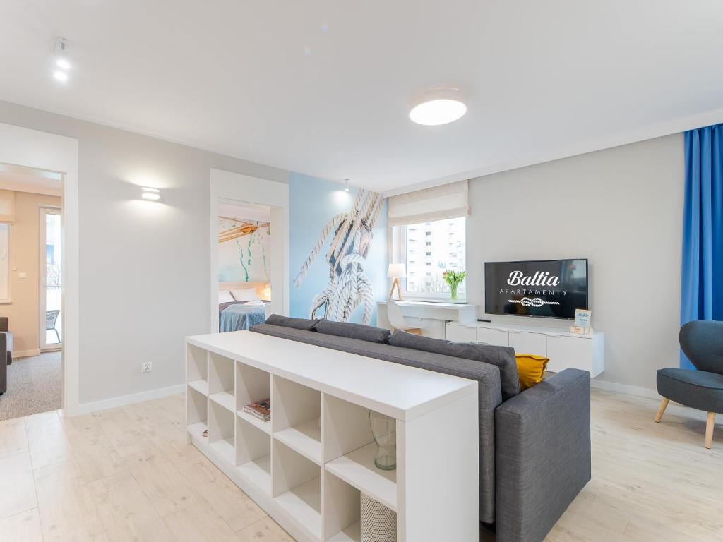 a living room with a couch and a tv at Apartamenty Baltia Kołobrzeg - Bliżej Morza in Kołobrzeg