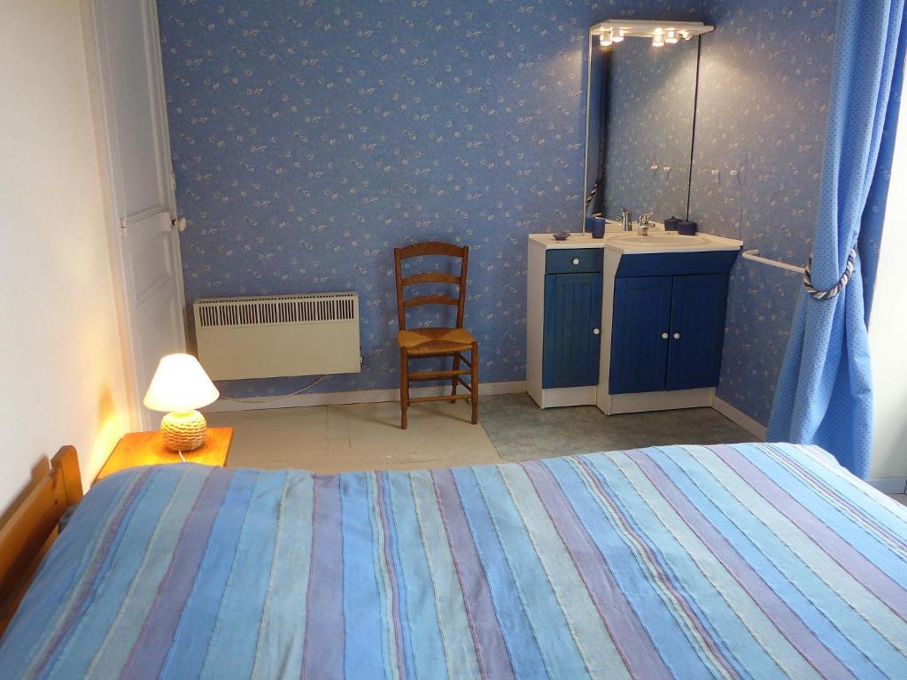 a bedroom with a bed and a sink and a chair at Holiday Home Le chant des milans by Interhome in Ondres