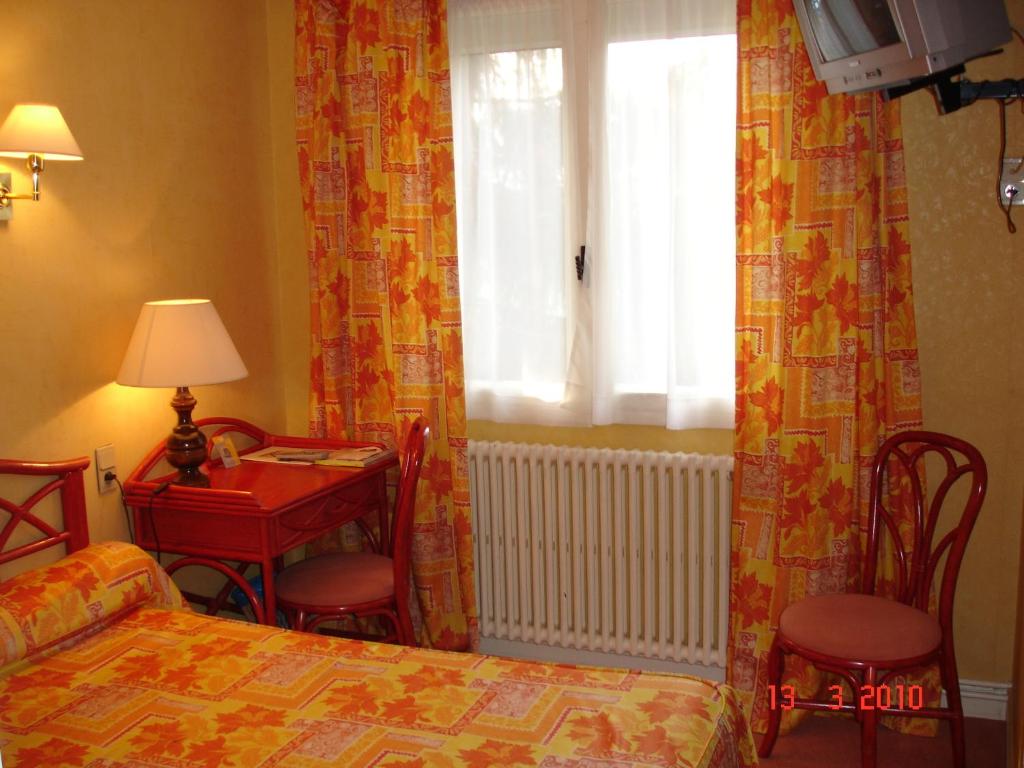 Postel nebo postele na pokoji v ubytování Logis Hôtel du Pont Neuf