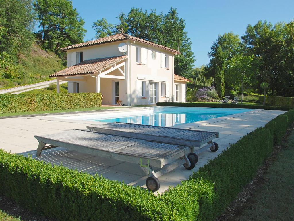 Saint-Pantaléon的住宿－聖潘塔萊翁拉佩瑞爾度假屋，房屋和游泳池前设有长凳