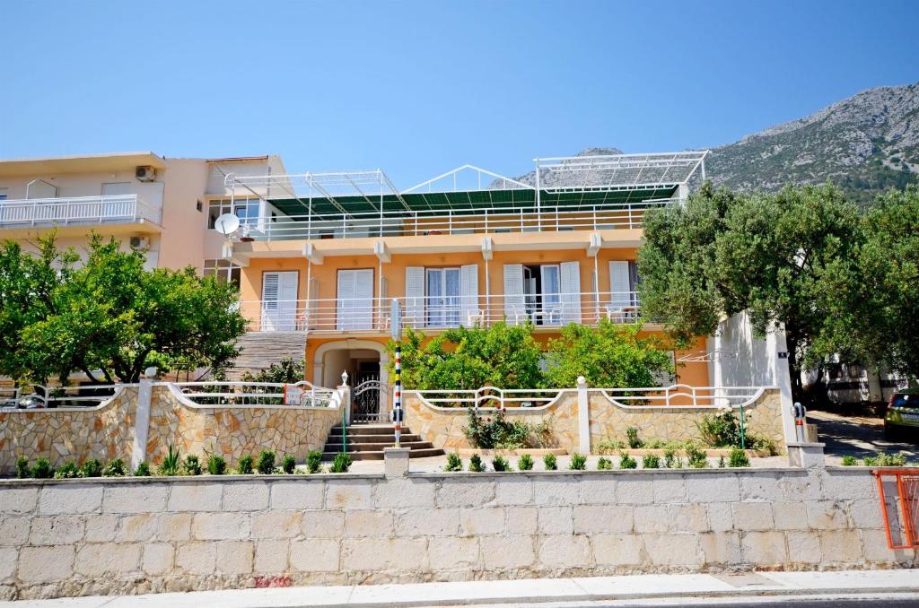 a large orange building with a fence in front of it at Apartments Josko in Gradac