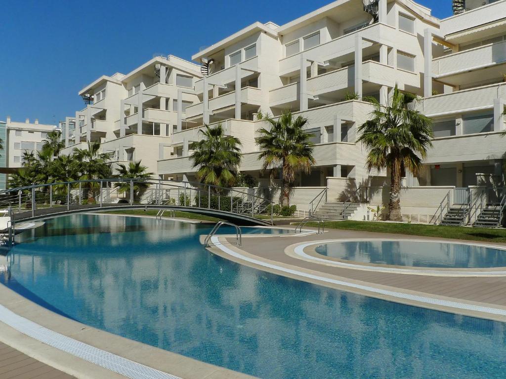 a swimming pool in front of a large apartment building at Apartment Elegance-2 by Interhome in Denia