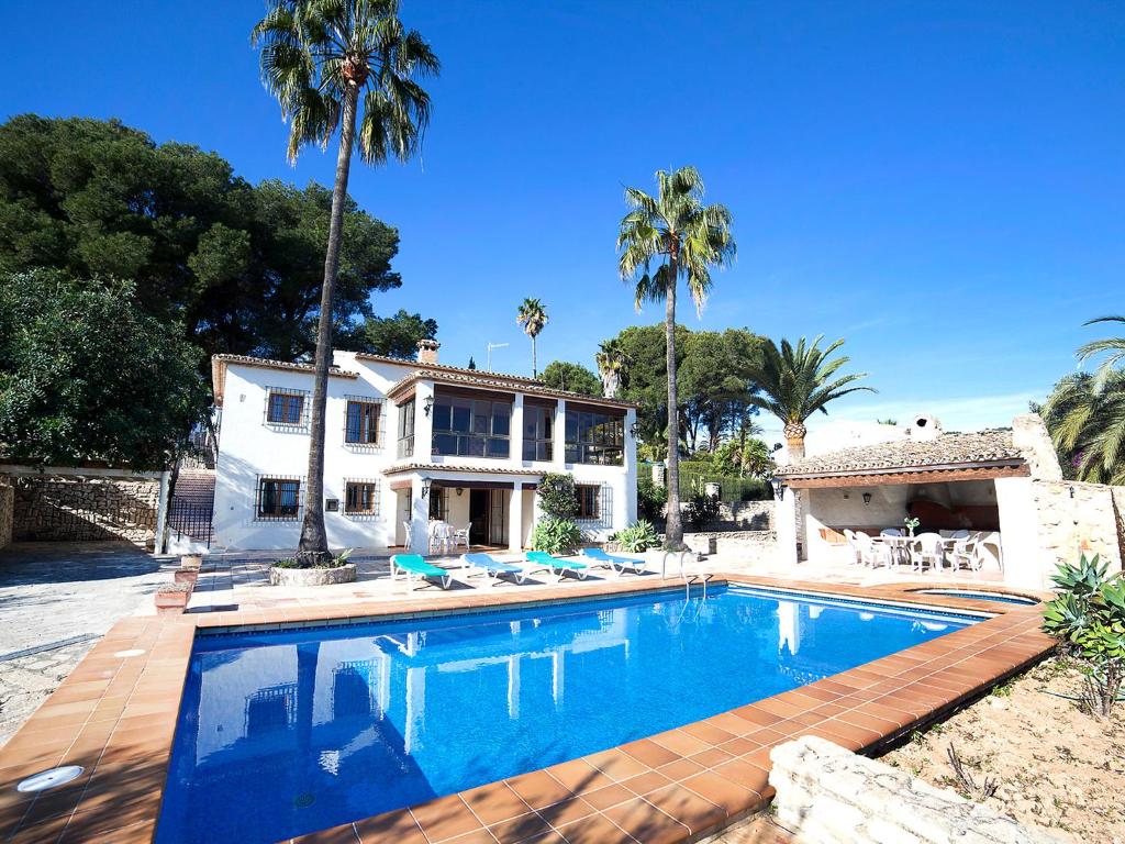 basen przed domem z palmami w obiekcie Holiday Home Els Pins by Interhome w mieście Benissa