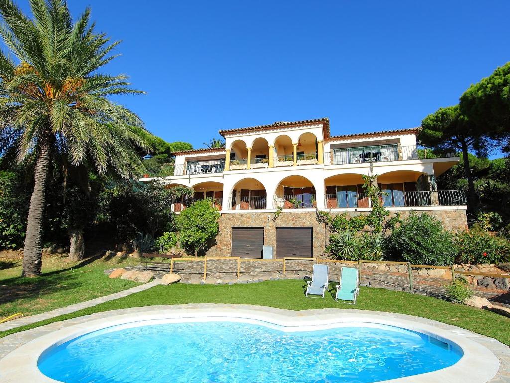 ein großes Haus mit Pool davor in der Unterkunft Holiday Home Puig Romani-1 by Interhome in Platja  d'Aro