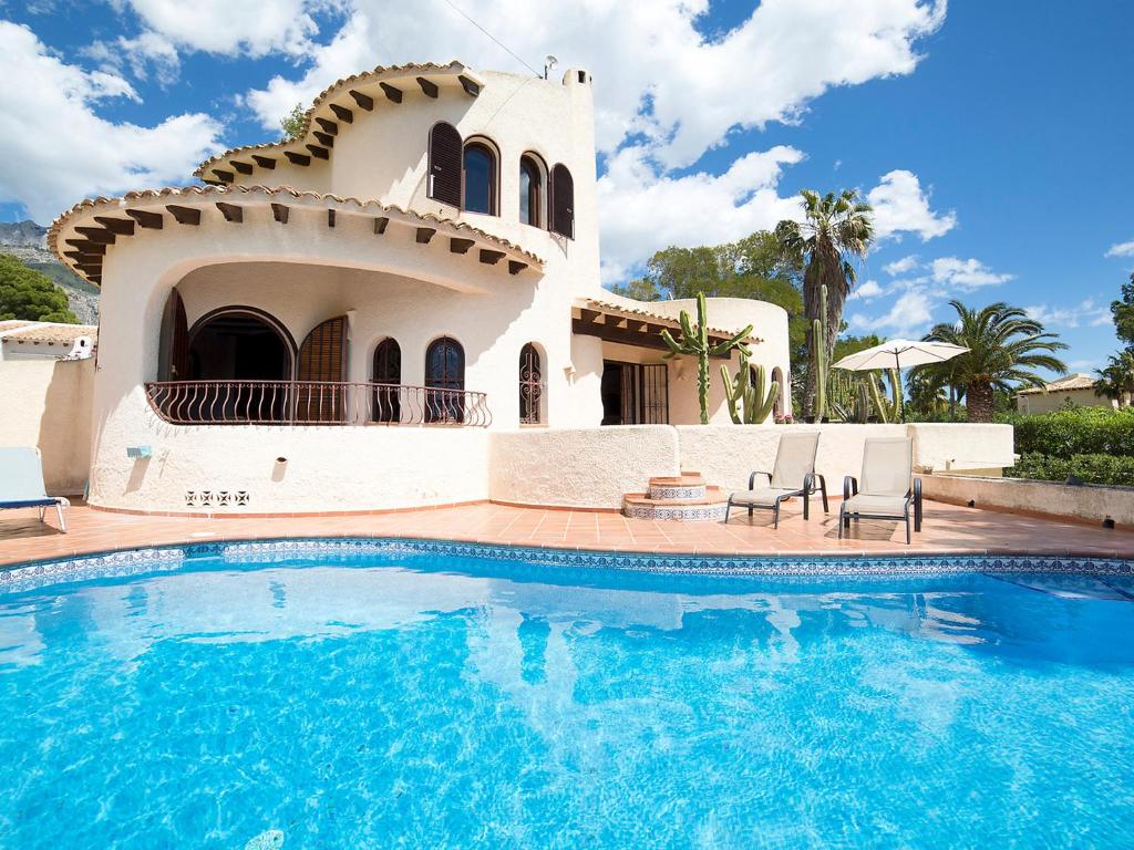 a villa with a swimming pool in front of a house at Holiday Home Luz y Paz by Interhome in Altea la Vieja