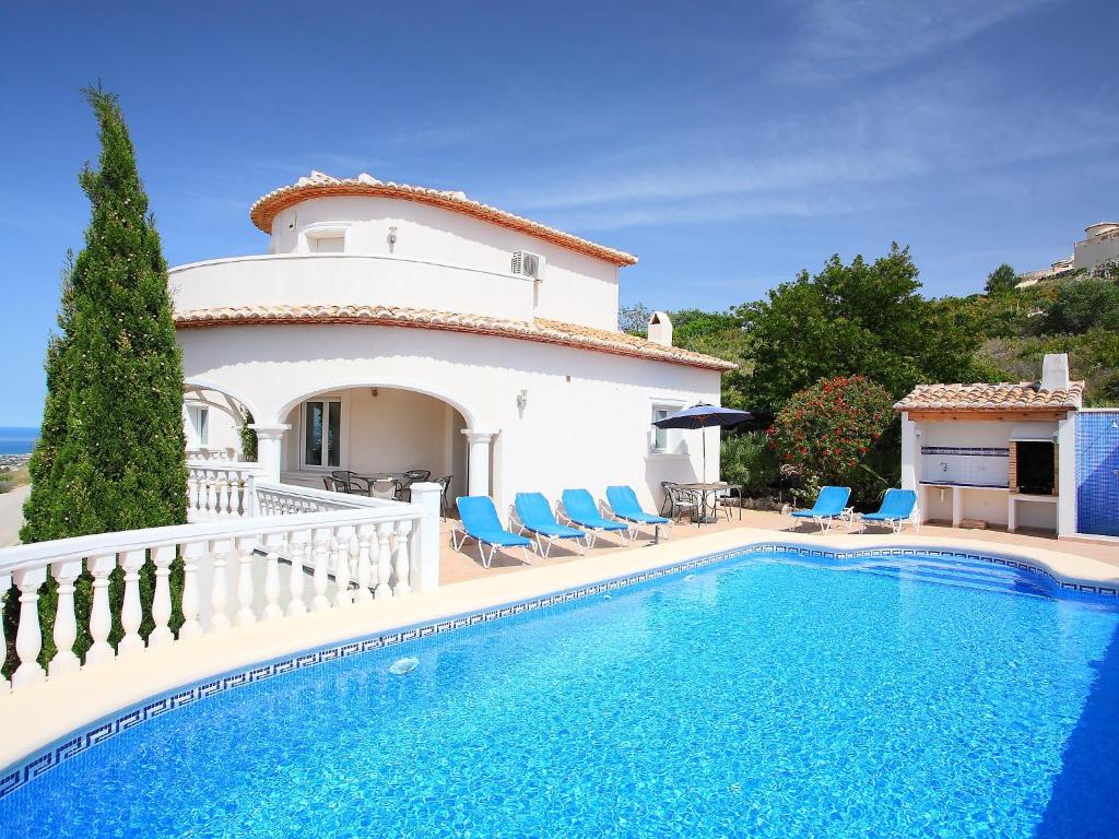 a villa with a swimming pool in front of a house at Villa Puesta del Sol by Interhome in Monte Pego