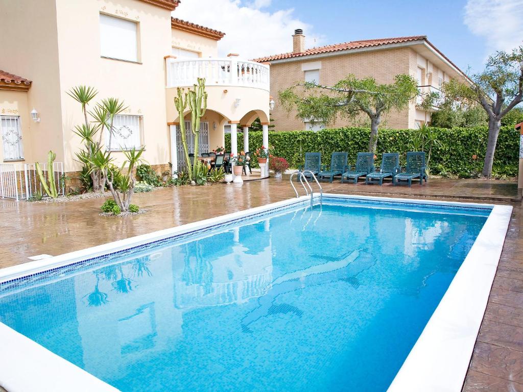 a swimming pool in front of a house at Holiday Home Mestral by Interhome in Alcanar