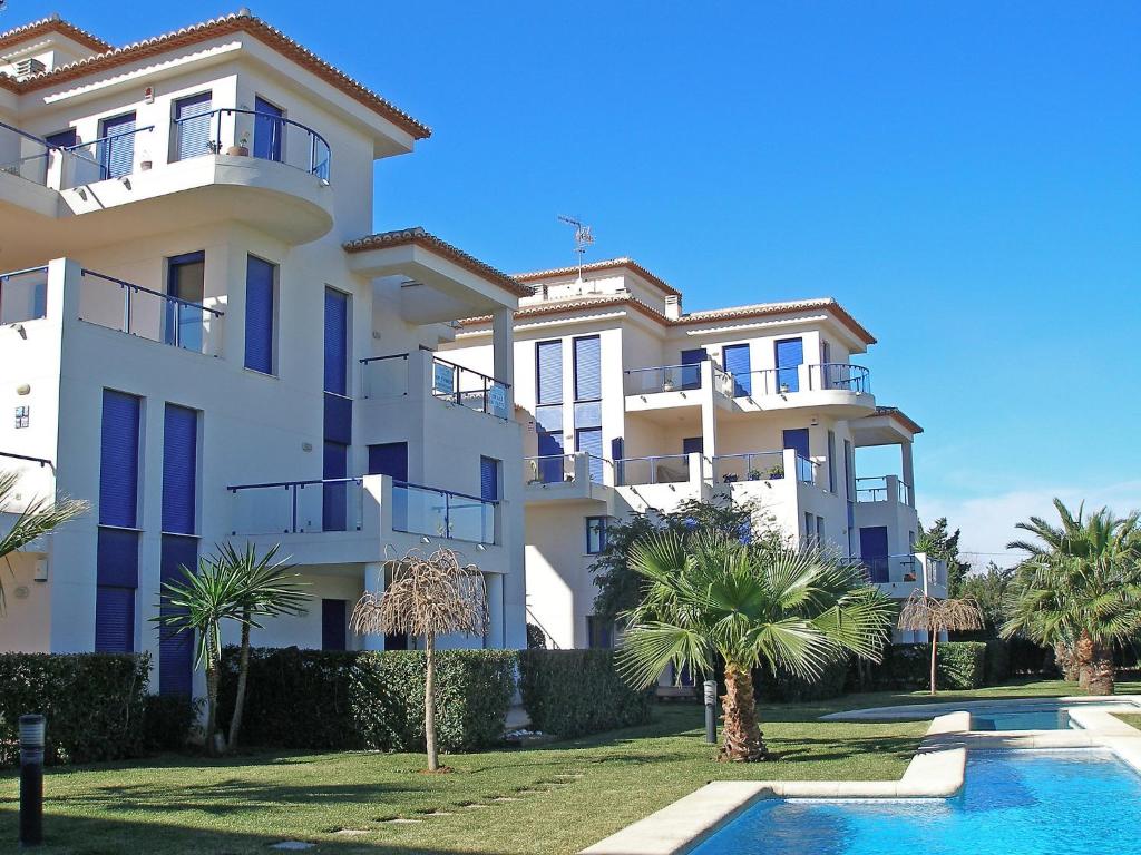 ein großes weißes Gebäude mit Palmen und einem Pool in der Unterkunft Apartment Alma del Sol by Interhome in Denia