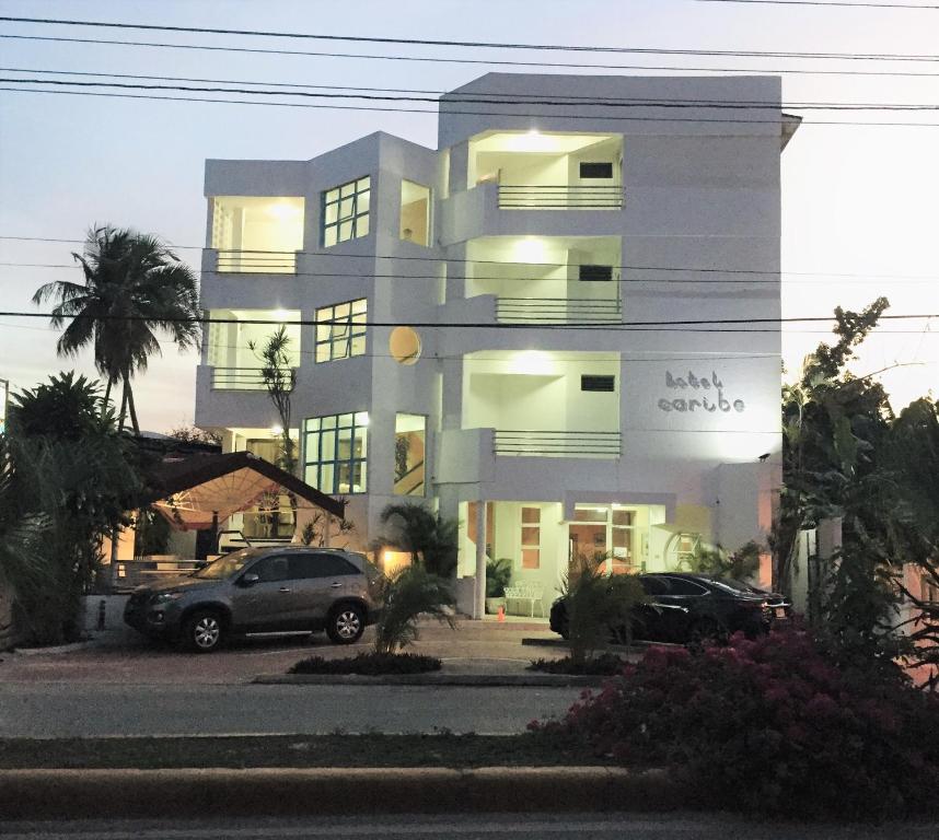 ein Gebäude, vor dem ein Auto geparkt ist in der Unterkunft Hotel Caribe in Santa Cruz de Barahona