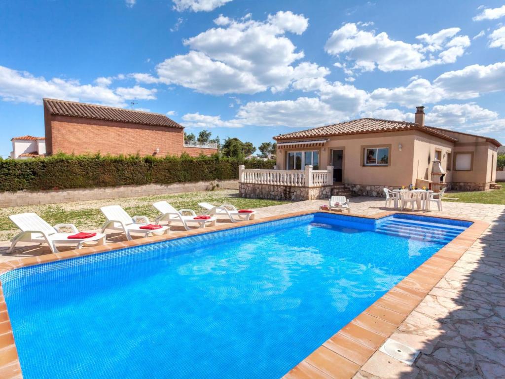una piscina con sedie e una casa di Villa Villa Llobeta by Interhome a Les tres Cales