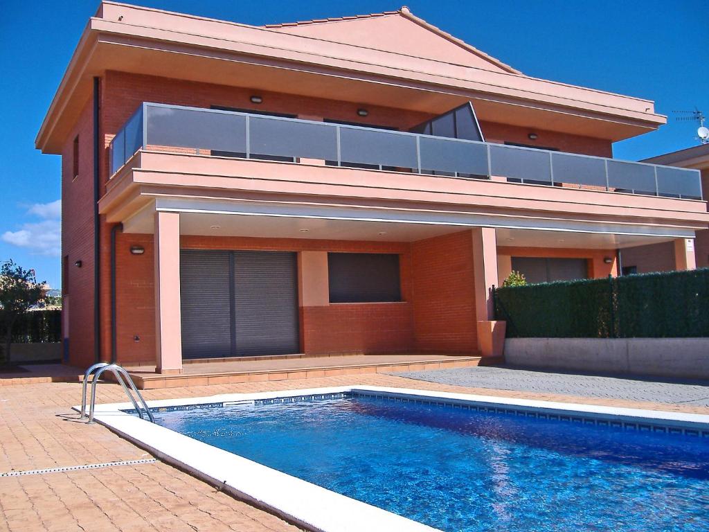 a house with a swimming pool in front of a house at Holiday Home Peiro by Interhome in L'Ampolla
