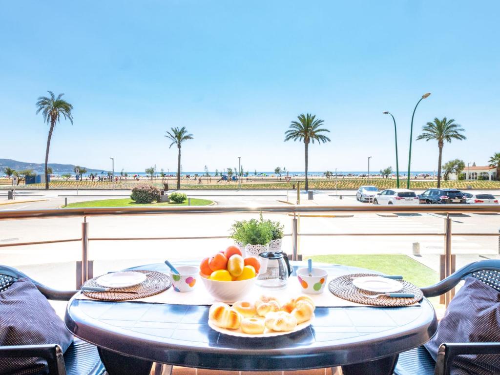 een tafel met een fruitschaal en uitzicht op het strand bij Apartment Edificio Blaucel by Interhome in Empuriabrava