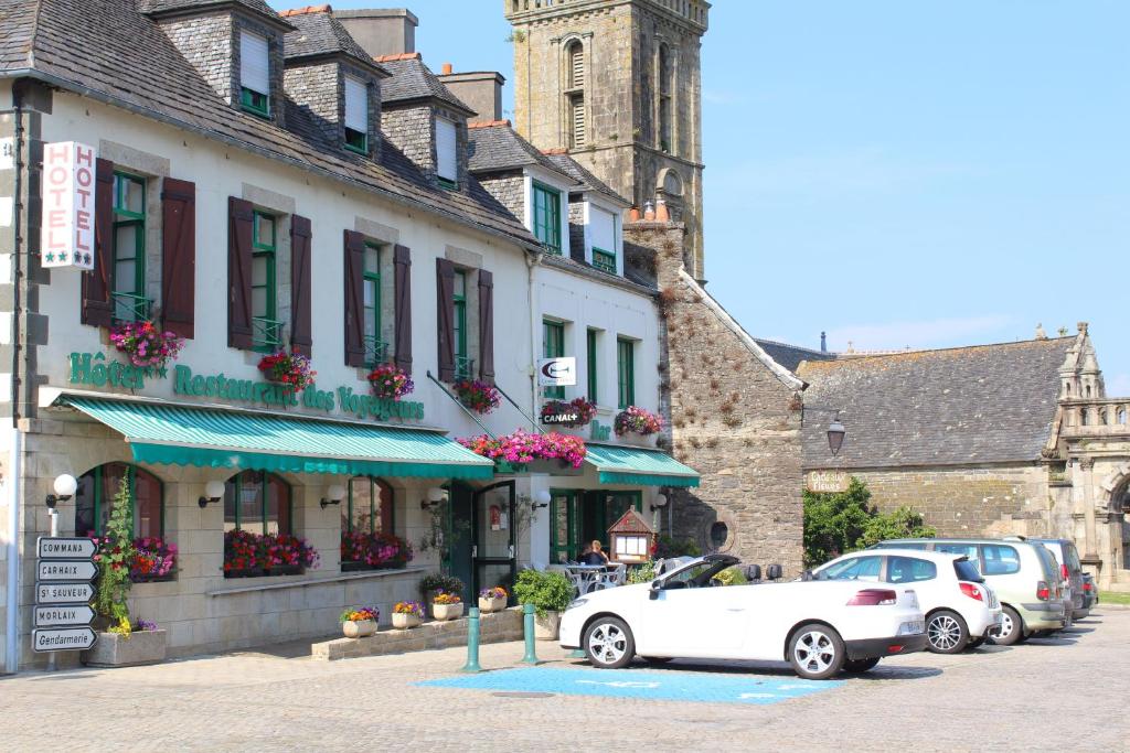 un coche blanco estacionado frente a un edificio en Les Voyageurs en Sizun