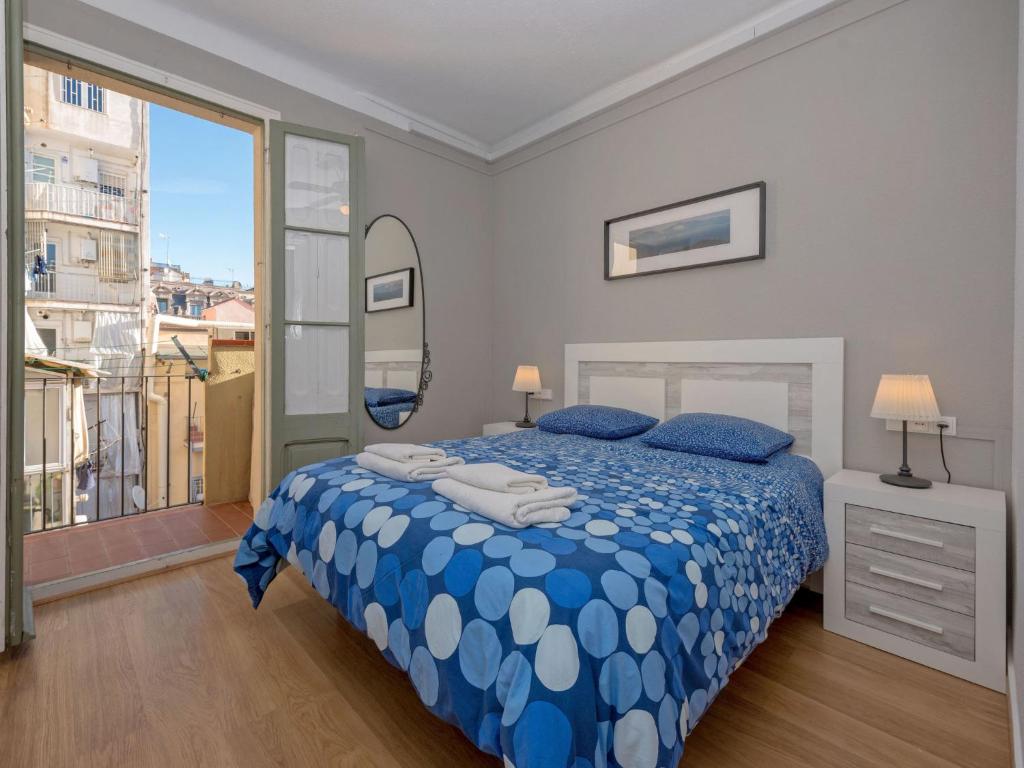 une chambre avec un lit bleu et blanc et une fenêtre dans l'établissement Apartment Sagrada Familia Grassot - Industria by Interhome, à Barcelone