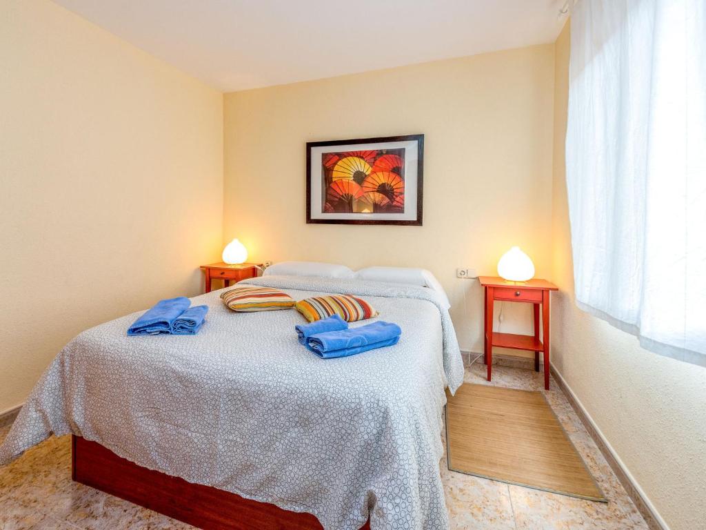 a bedroom with a bed with two blue towels on it at Apartment Camp Nou- Travessera de les Corts by Interhome in Barcelona