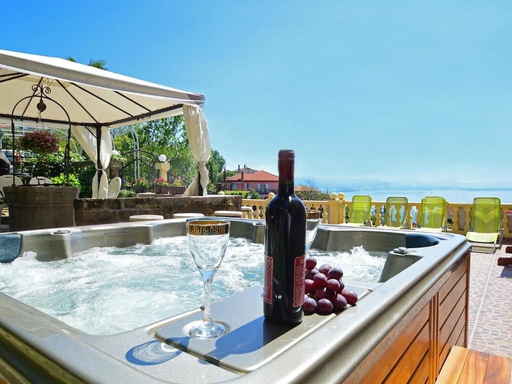 a bottle of wine and a wine glass in a hot tub at Apartment Andrea by Interhome in Opatija