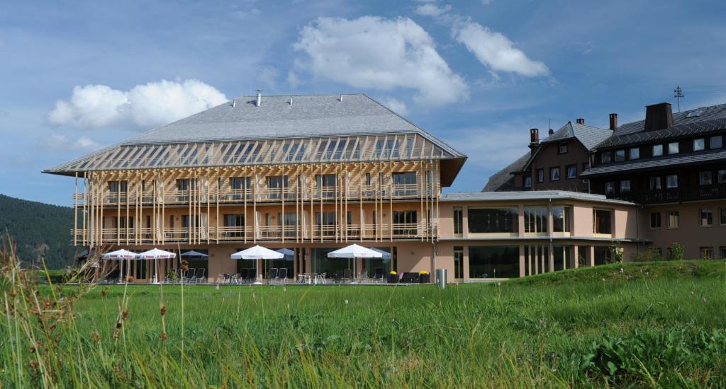 ein großes Gebäude mit Sonnenschirmen davor in der Unterkunft Natur & Wellnesshotel Breggers Schwanen - Bernau im Schwarzwald in Bernau im Schwarzwald