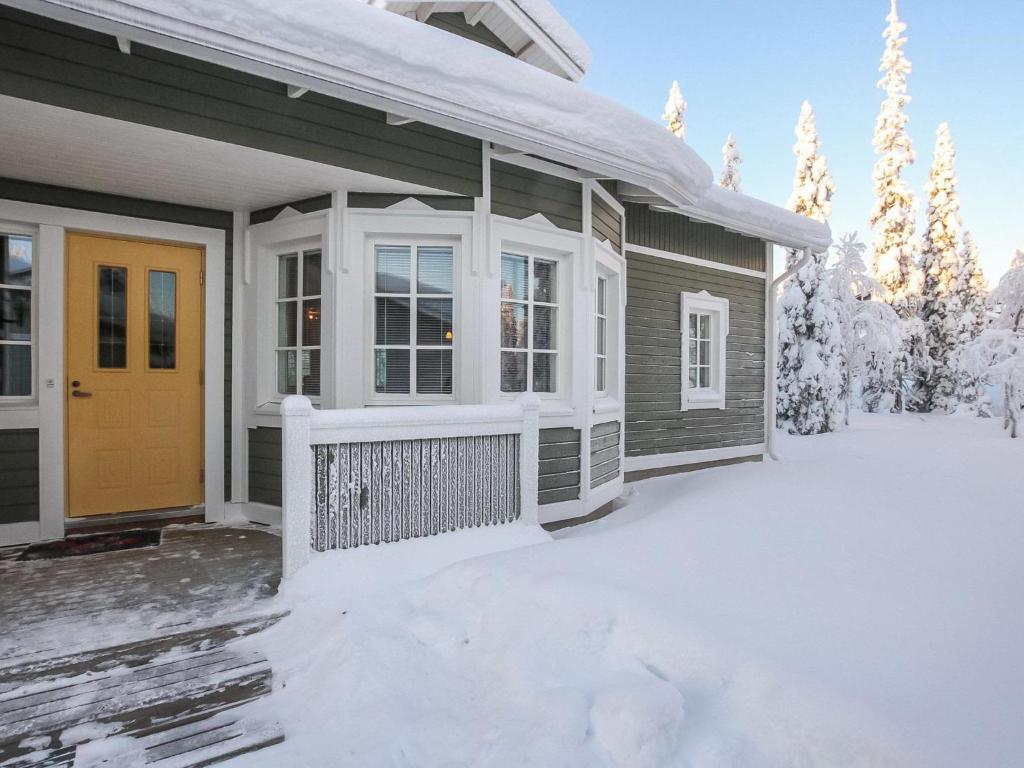ルカにあるHoliday Home Rukan taikavuosselin helmi 8 a by Interhomeの雪の中の黄色い扉のある家