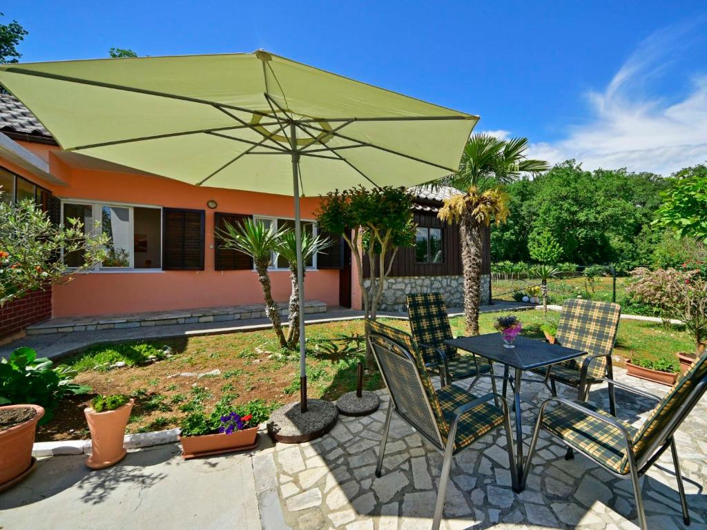 a patio with a table and chairs and an umbrella at Holiday Home Franjo-2 by Interhome in Ika